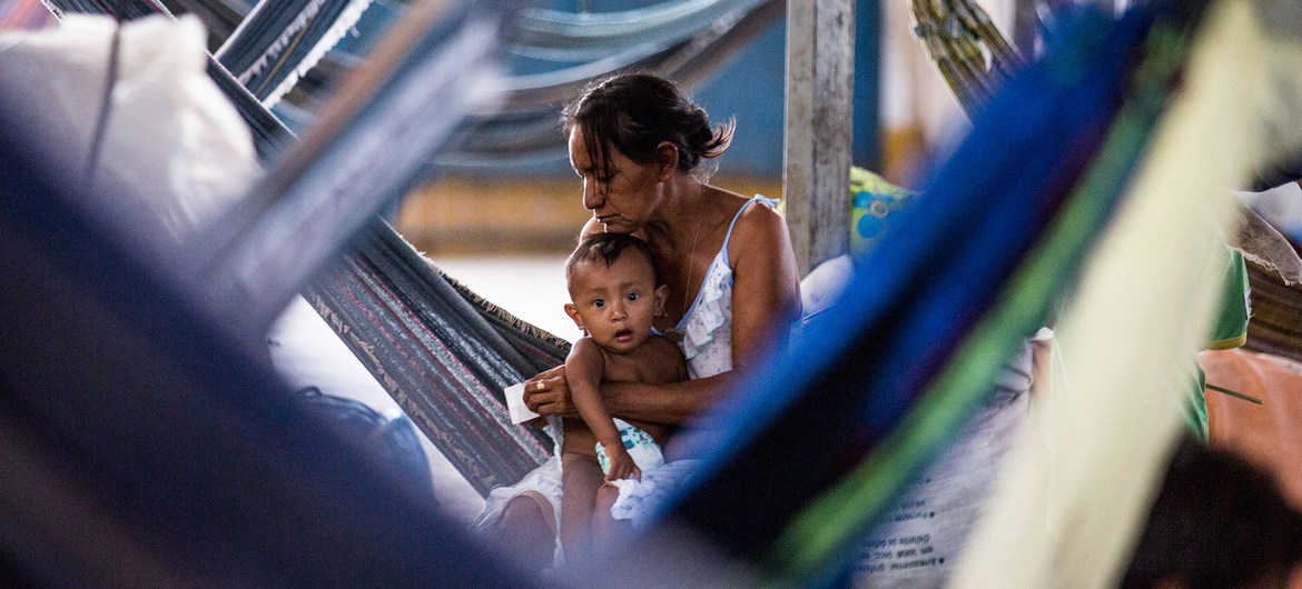 Una madre cuida de su bebé dentro de un gimnasio que se ha convertido en un asentamiento de refugiados en Pintolandia, en el Estado brasileño de Roraima, fronterizo con Venezuela.