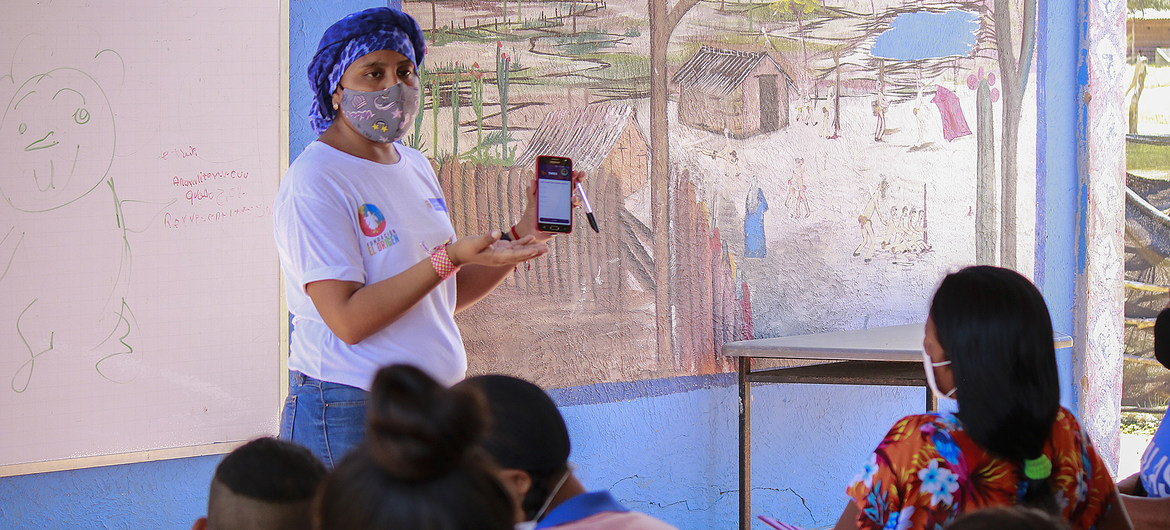Fundación El Origen Una maestra explica cómo usar la aplicación para acceder al material educativo en los dispositivos móviles. La Guajira, Colombia