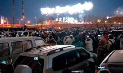 Personas cercanas al Estadio Nacional ven fuegos artificiales en la Ceremonia de Apertura de Beijing 2022