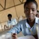 Esta adolescente está realizando un experimento durante una clase de química en la Escuela secundaria de Kamulanga en Lusaka (Zambia). FOTO:UNICEF/UN0145554/Karin Schermbrucker.