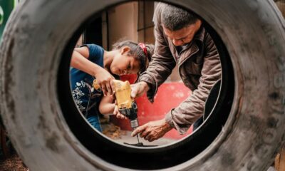 Un migrante venezolano y su hija pequeña realizan reparaciones en su casa de Ecuador.